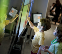 Children interact with the OptIPortable at the Knowledge Exchange Corridors exhibition at the galler