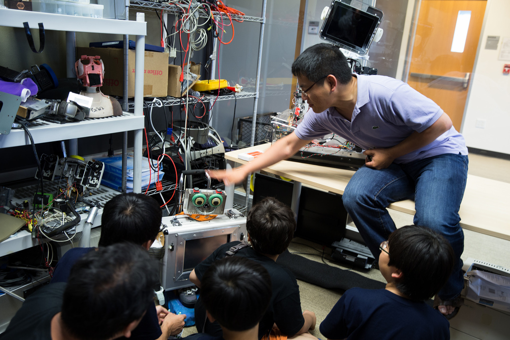 QI researcher Tingfan Wu shows elementary school students in the Robolink program the RUBI robot