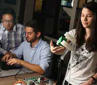 Ph.D. students Benjamin Shih and Dylan Drotman monitor a computer while Ph.D. student Adriane Minori
