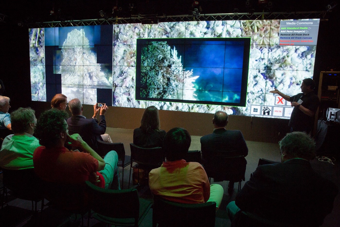 Figure 2. The large Video Wall in the Qualcomm Institute V-Room hosts several high-resolution images of the Mushroom structure, and a live feed of HD Video directly from the seafloor as an inset.  Audience members can be seen in the foreground, giving a sense of the size of the display (10 feet high x 36 feet long).