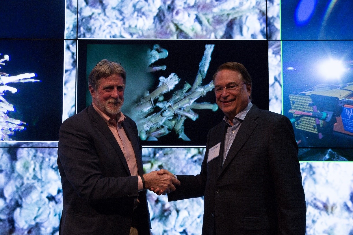 John Delaney and Larry Smarr celebrate the achievement of delivery of remote-controlled live HD video to the tiled display behind them in Clait2s Qualcomm Institute.